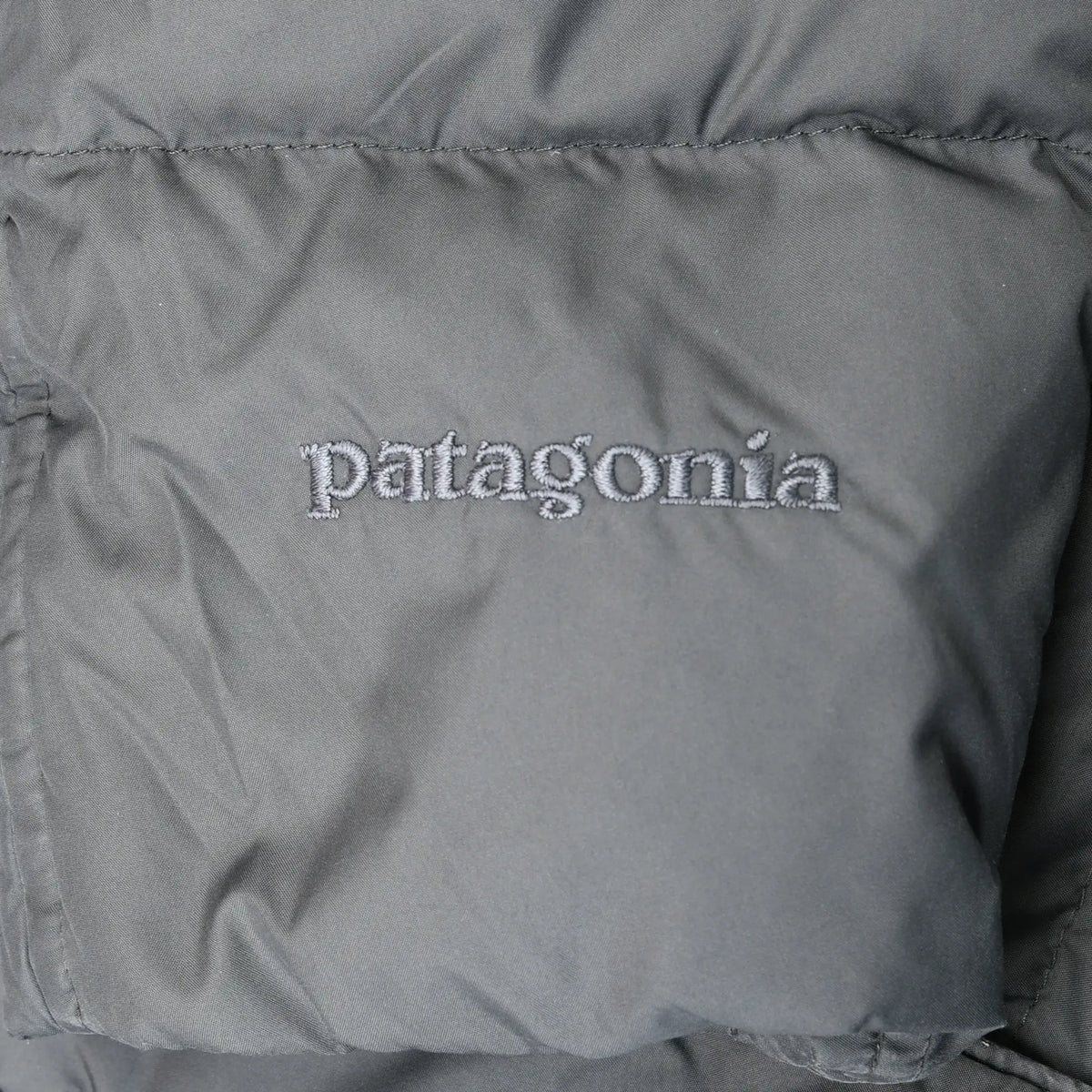 Close-up of Patagonia logo embroidery on gray parka fabric