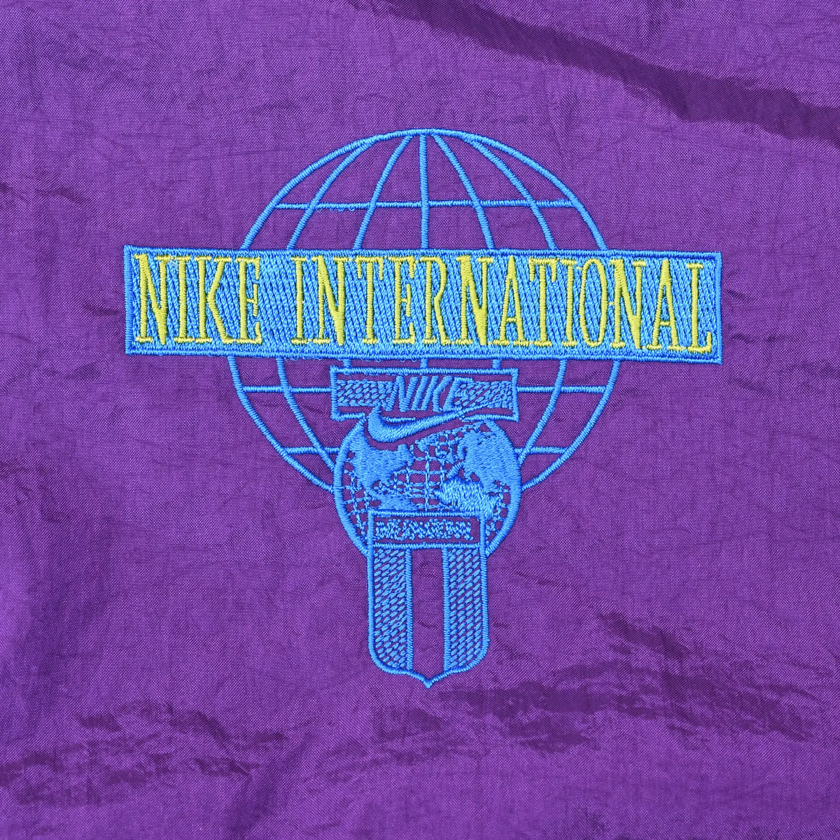 Nike International globe logo embroidery on purple back