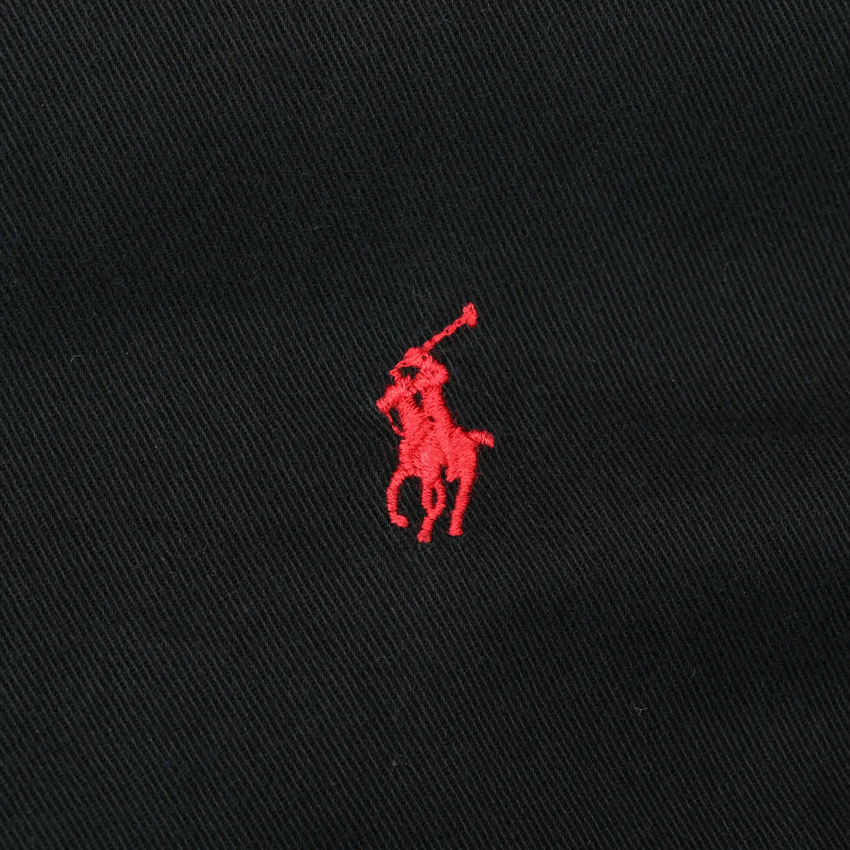 Close-up of red Ralph Lauren pony embroidery on black shirt fabric