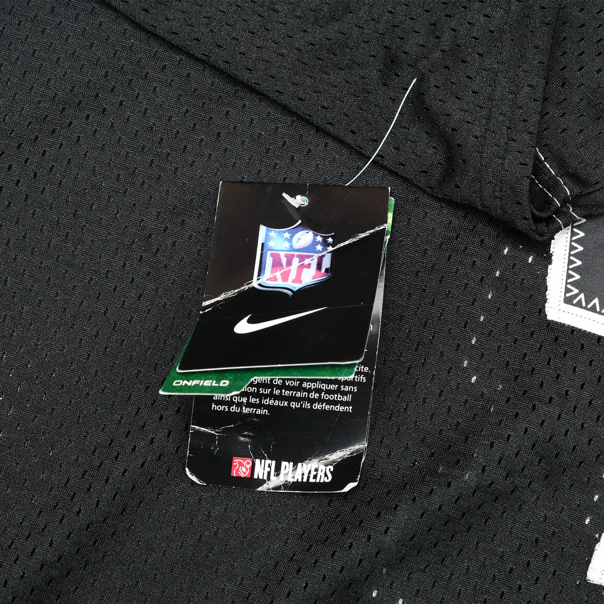 Nike NFL and NFL Players hangtags attached to black mesh jersey