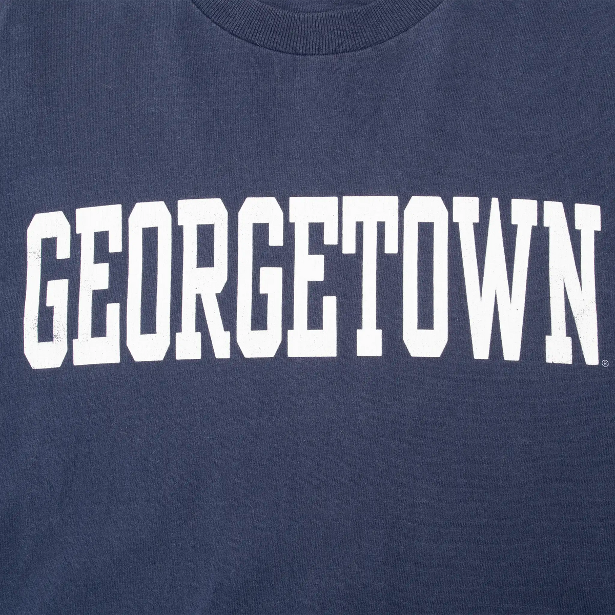 Close-up of white Georgetown print on navy T-shirt