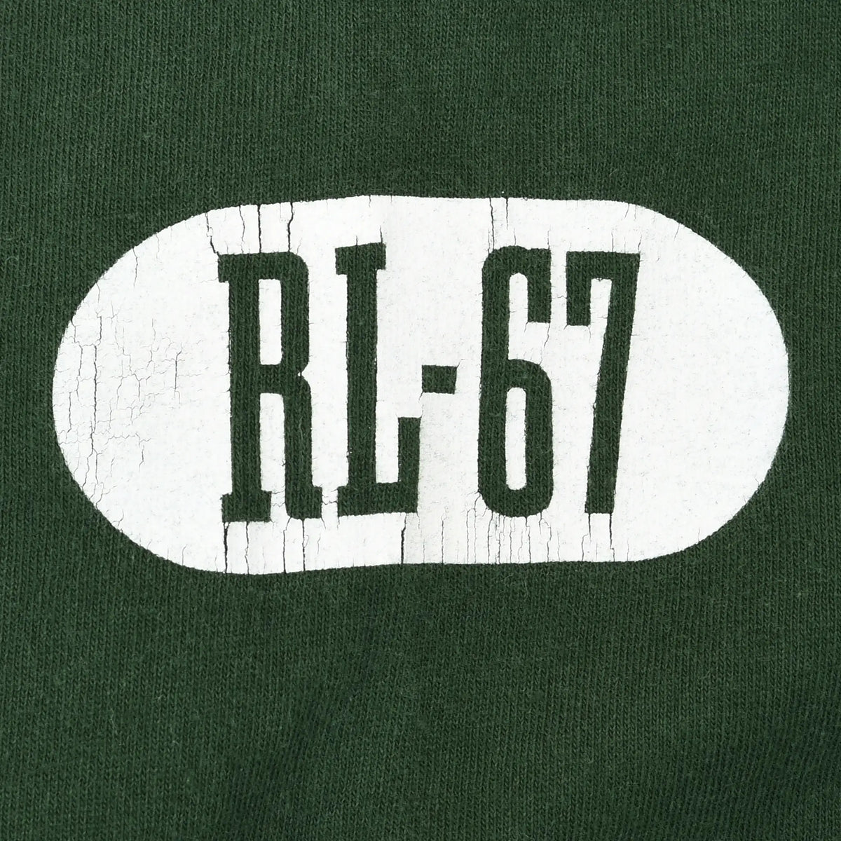 Close-up of cracked white RL-67 sleeve print on green fabric