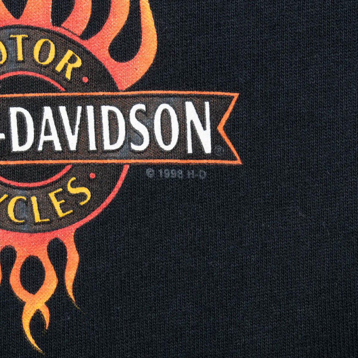 Close-up of 1998 copyright mark beside the Harley-Davidson flame print