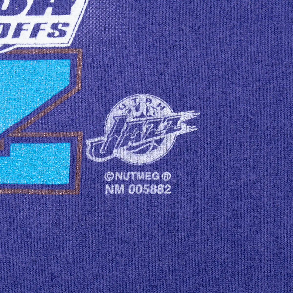 Close-up of Nutmeg Utah Jazz licensing mark on purple fabric