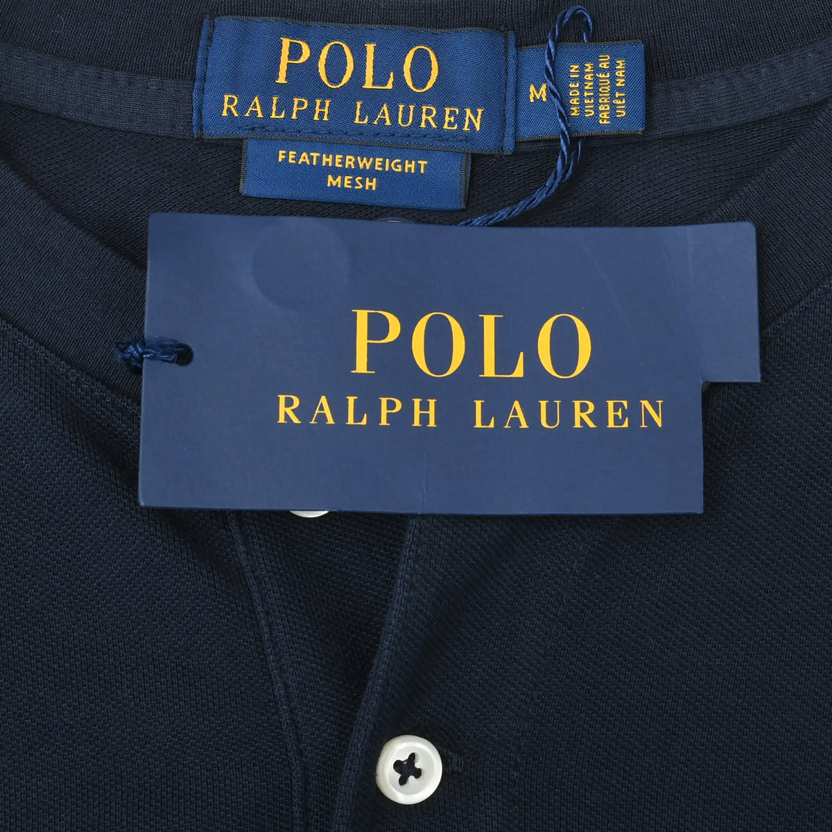 Polo Ralph Lauren neck label, medium size tag, and hangtag on navy Henley shirt