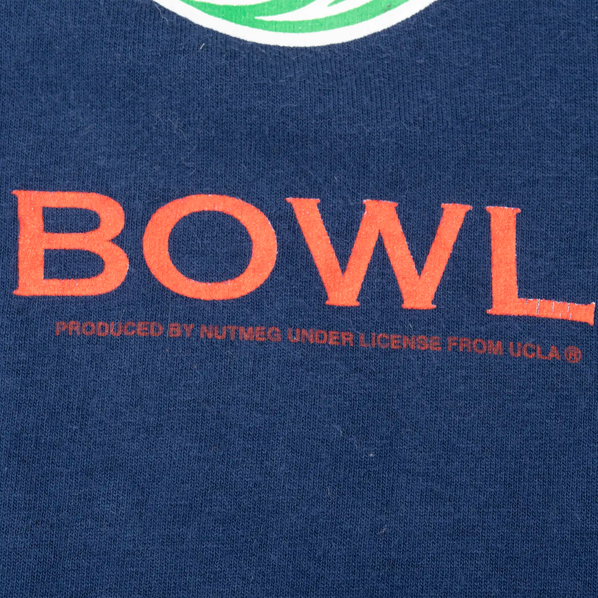 Close-up of Rose Bowl print licensing text on navy fabric
