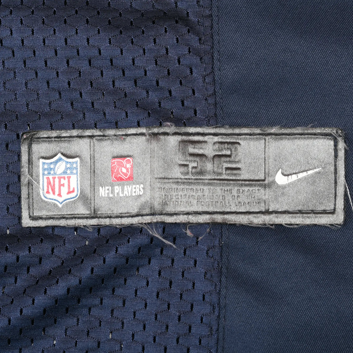 Close-up of NFL Players and Nike lower hem label on navy mesh jersey
