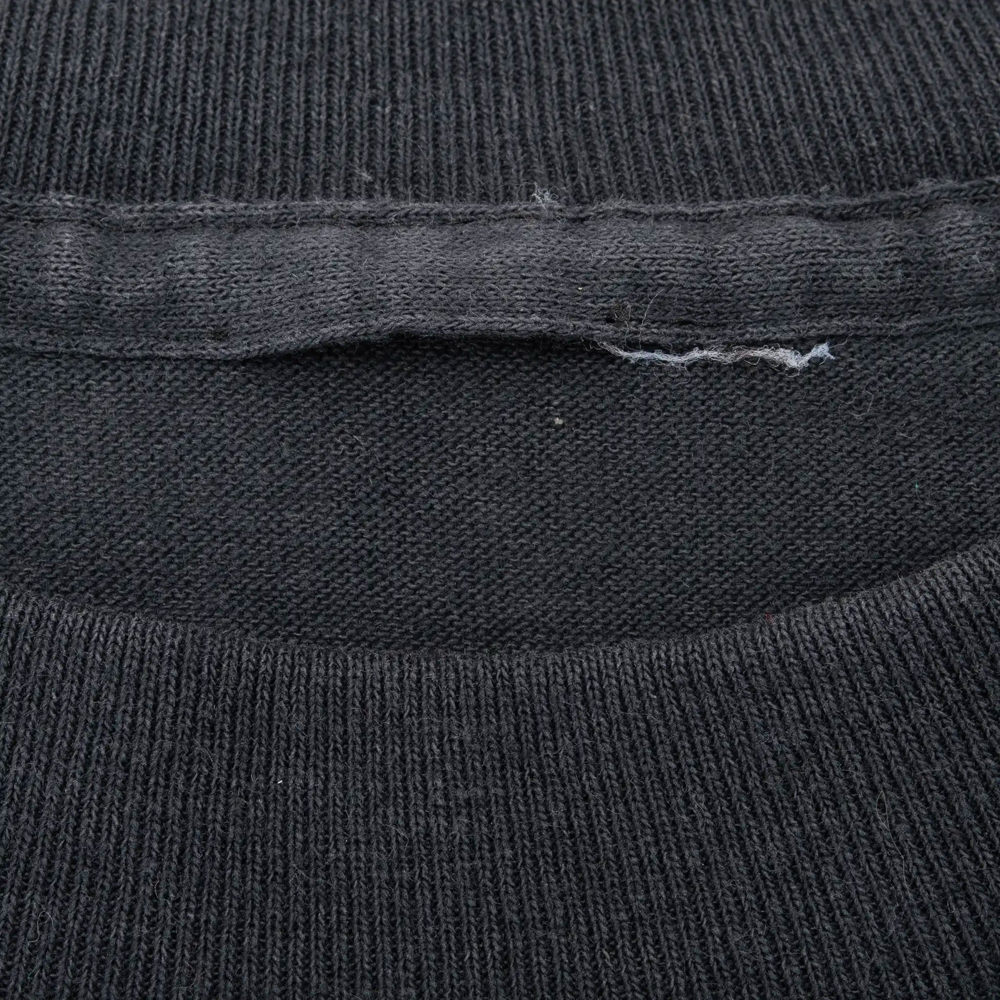 Close-up of black T-shirt's interior crew neck and faded tag area