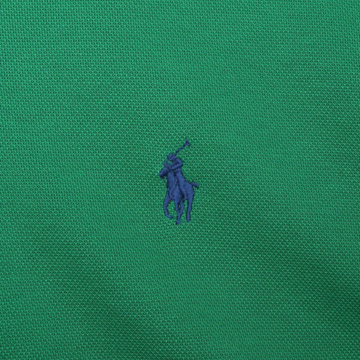 Close-up of navy Polo pony embroidery on green sweater