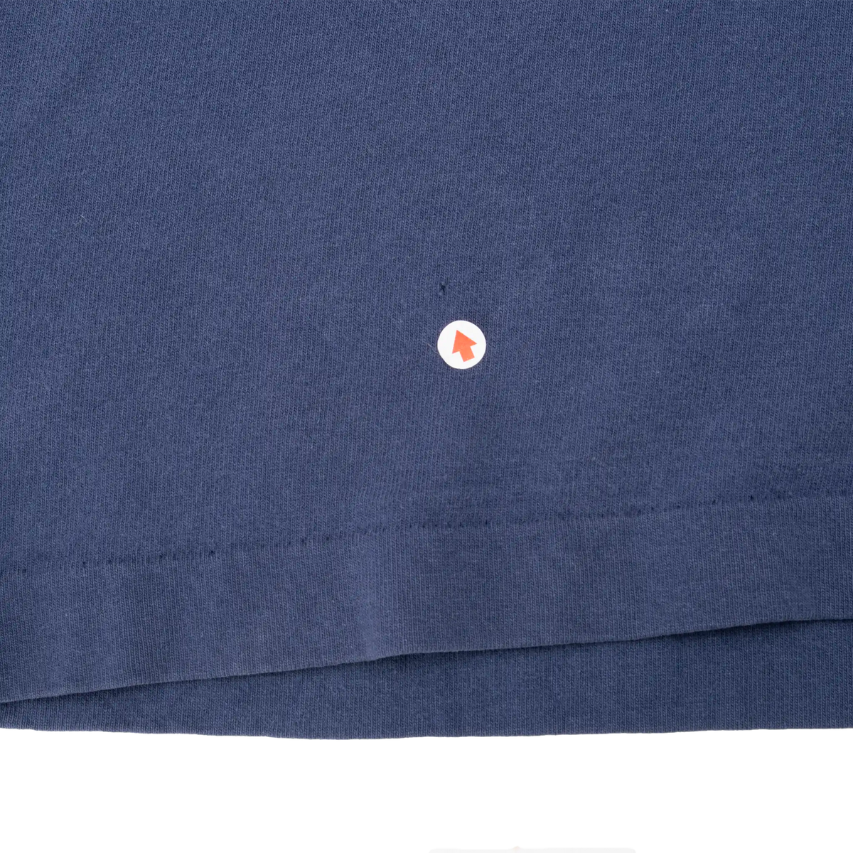 Close-up of navy fabric and bottom hem with a small mark