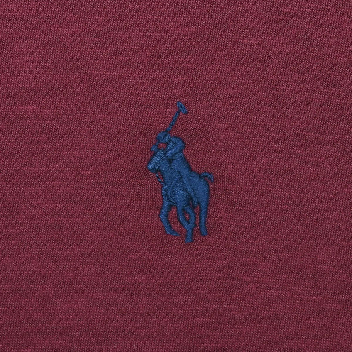 Close-up of navy Polo pony embroidery on burgundy fabric
