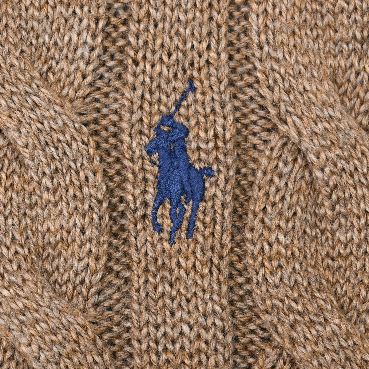 Close-up of blue Polo pony embroidery on brown cable-knit sweater