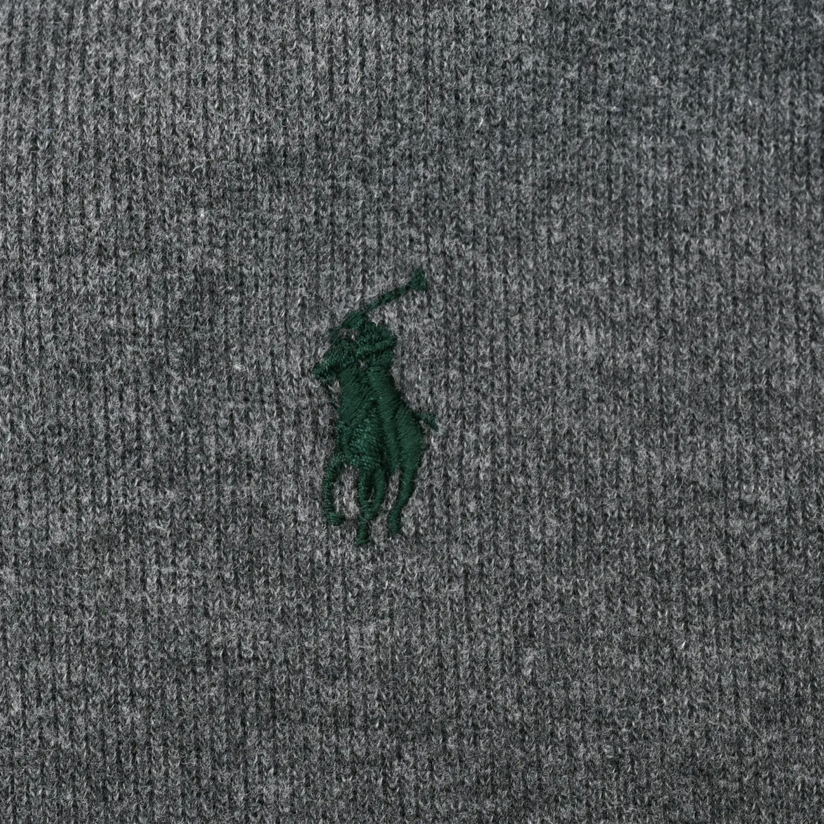 Close-up of green Polo pony embroidery on dark grey sweater