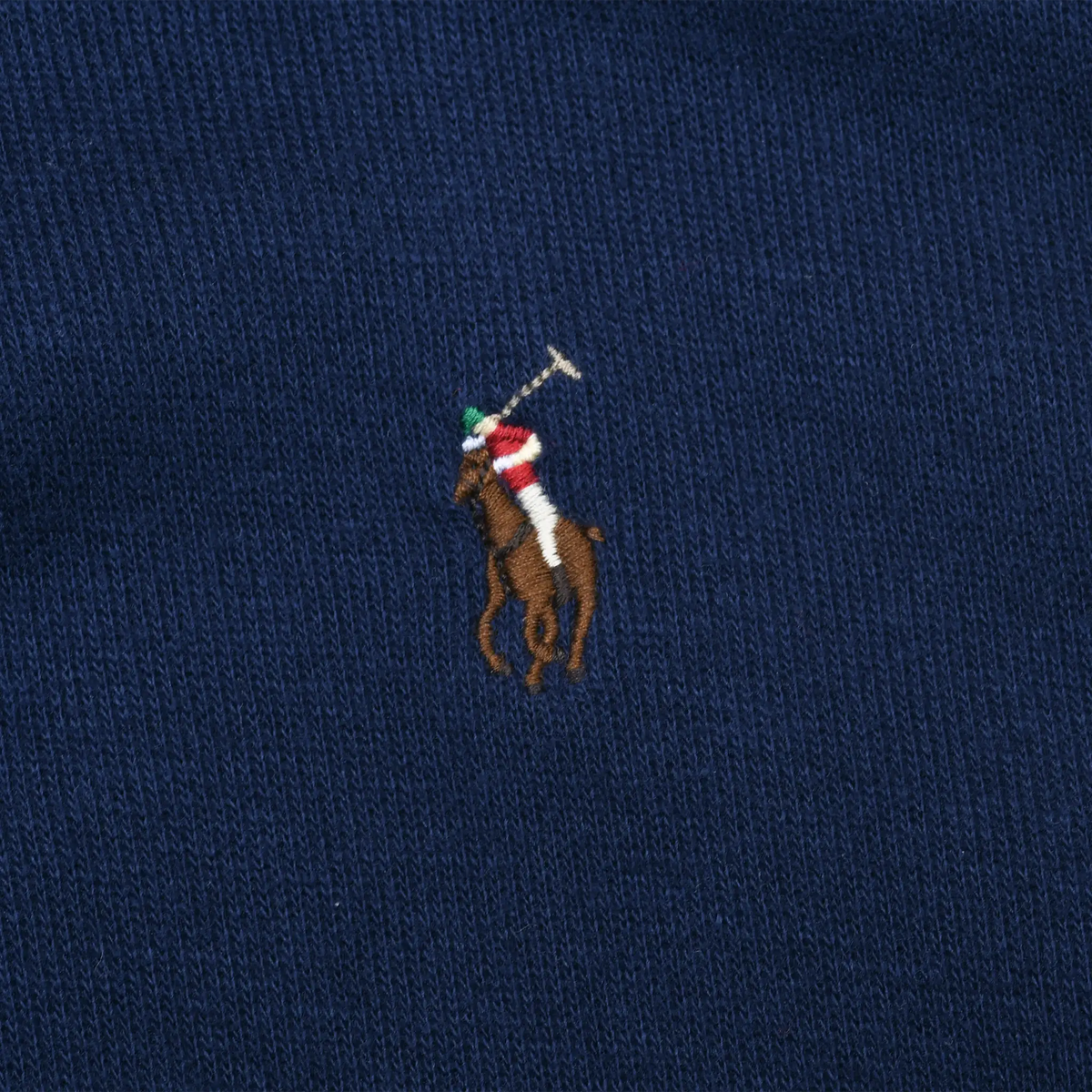 Close-up of multicolor Polo pony embroidery on navy blue sweater
