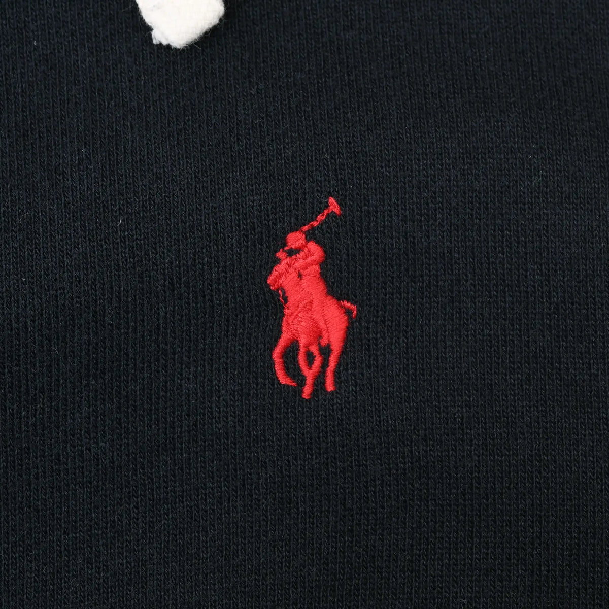 Close-up of red Polo pony embroidery on black hoodie chest
