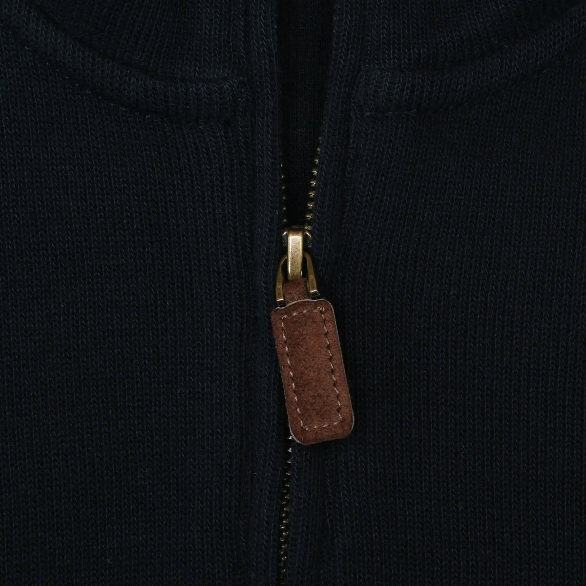 Close-up of quarter-zip closure with brown pull on black Polo Ralph Lauren sweater