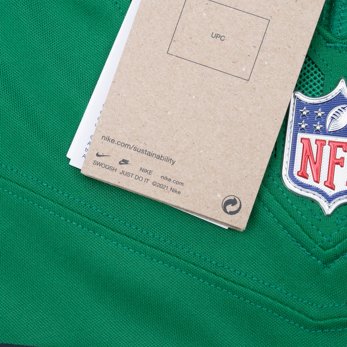 Close-up of Nike hangtag and NFL shield at the green jersey's V-neck
