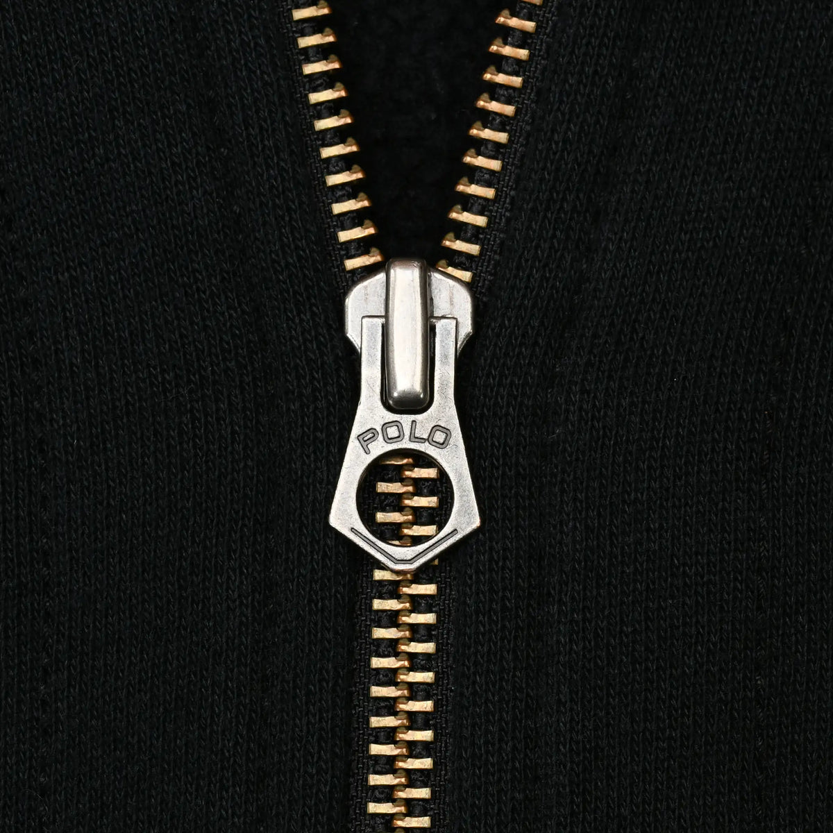 Close-up of metal zipper and Polo-engraved pull on black hoodie