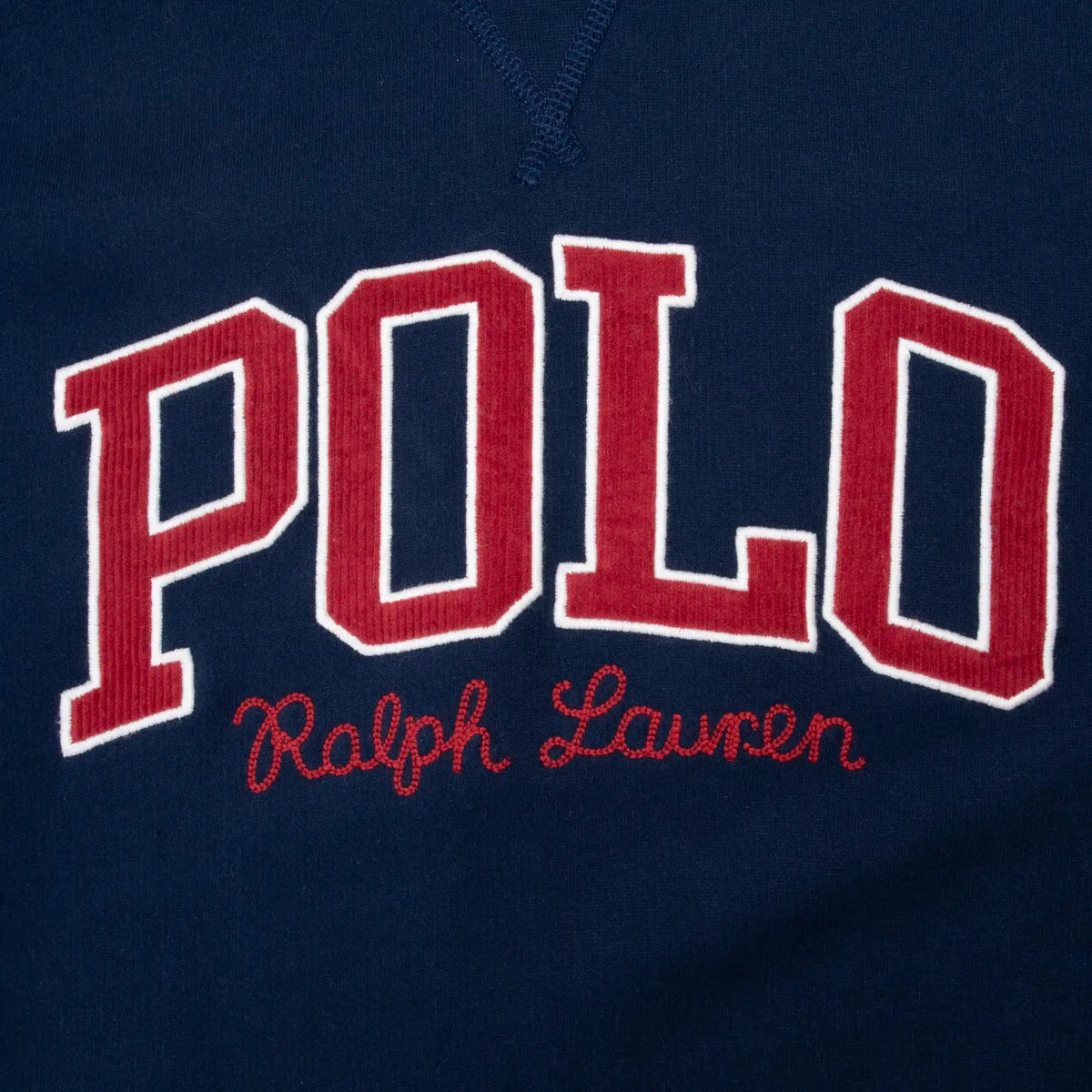 Close-up of red and white POLO Ralph Lauren chest embroidery on navy hoodie