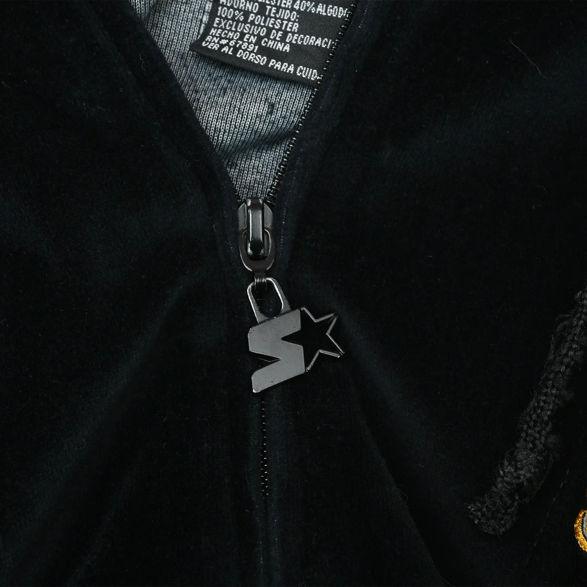 Close-up of black zipper with Starter star logo pull on velvet hoodie