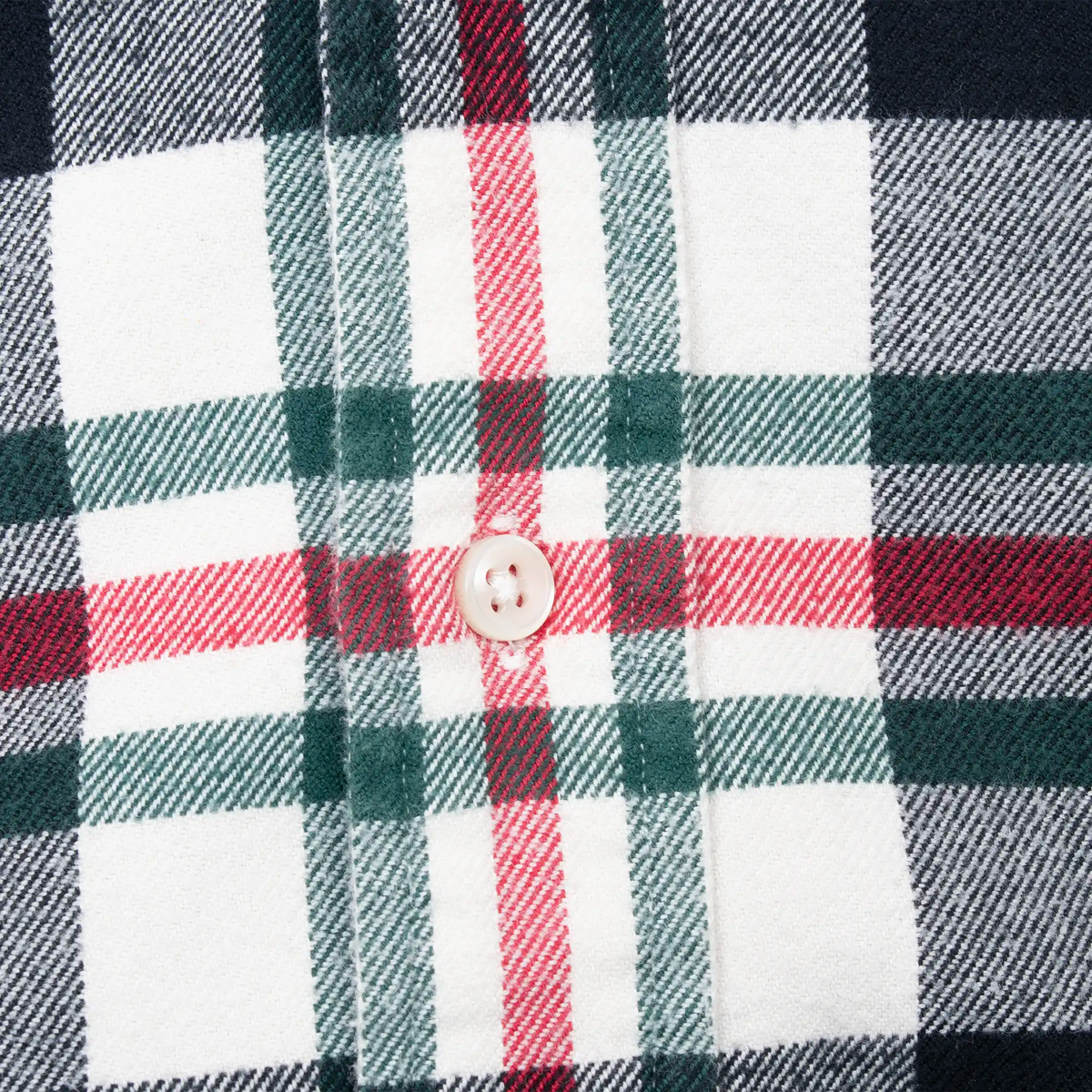 White button detail on the shirt's red, green, navy and white plaid fabric