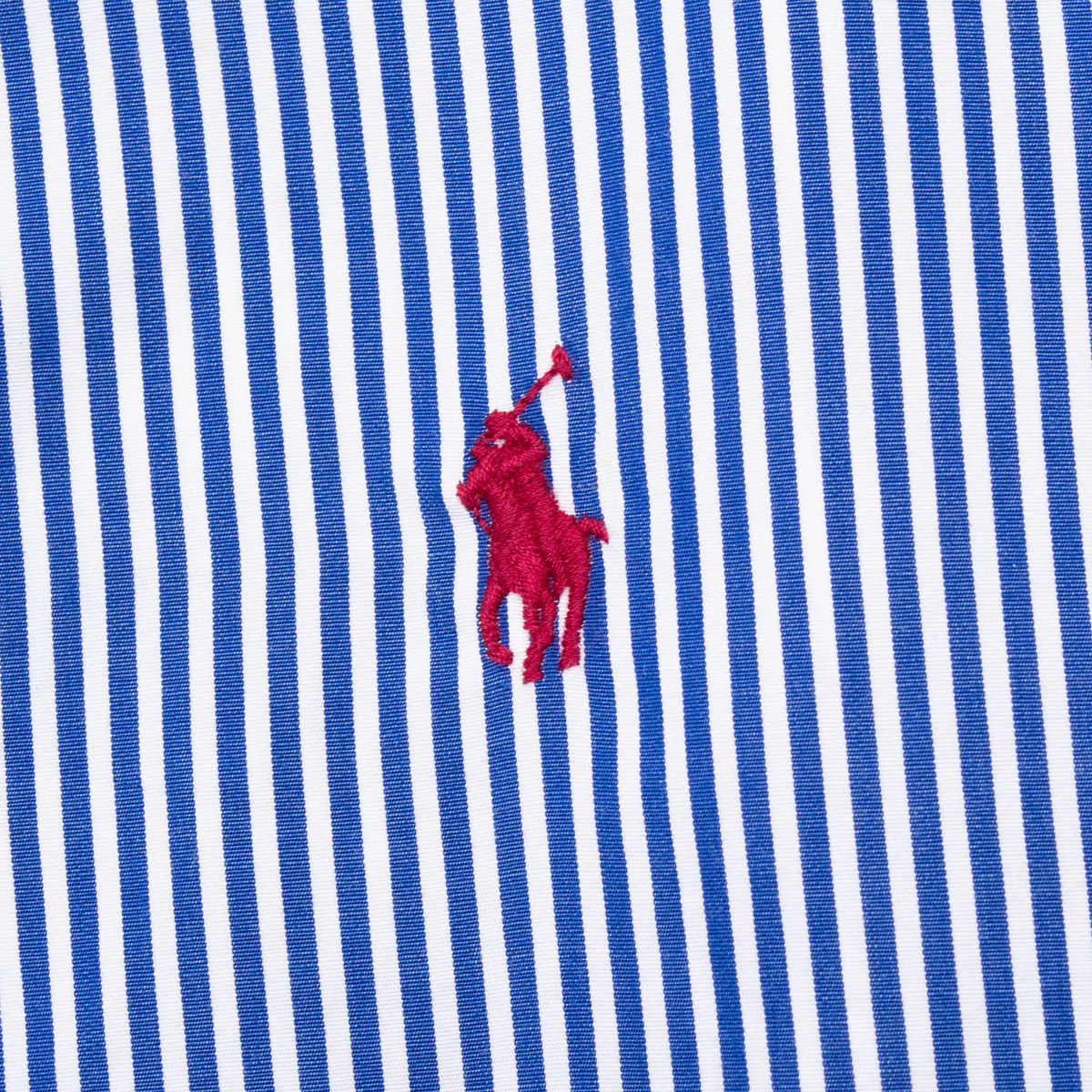 Close-up of red Ralph Lauren polo player embroidery on blue striped fabric