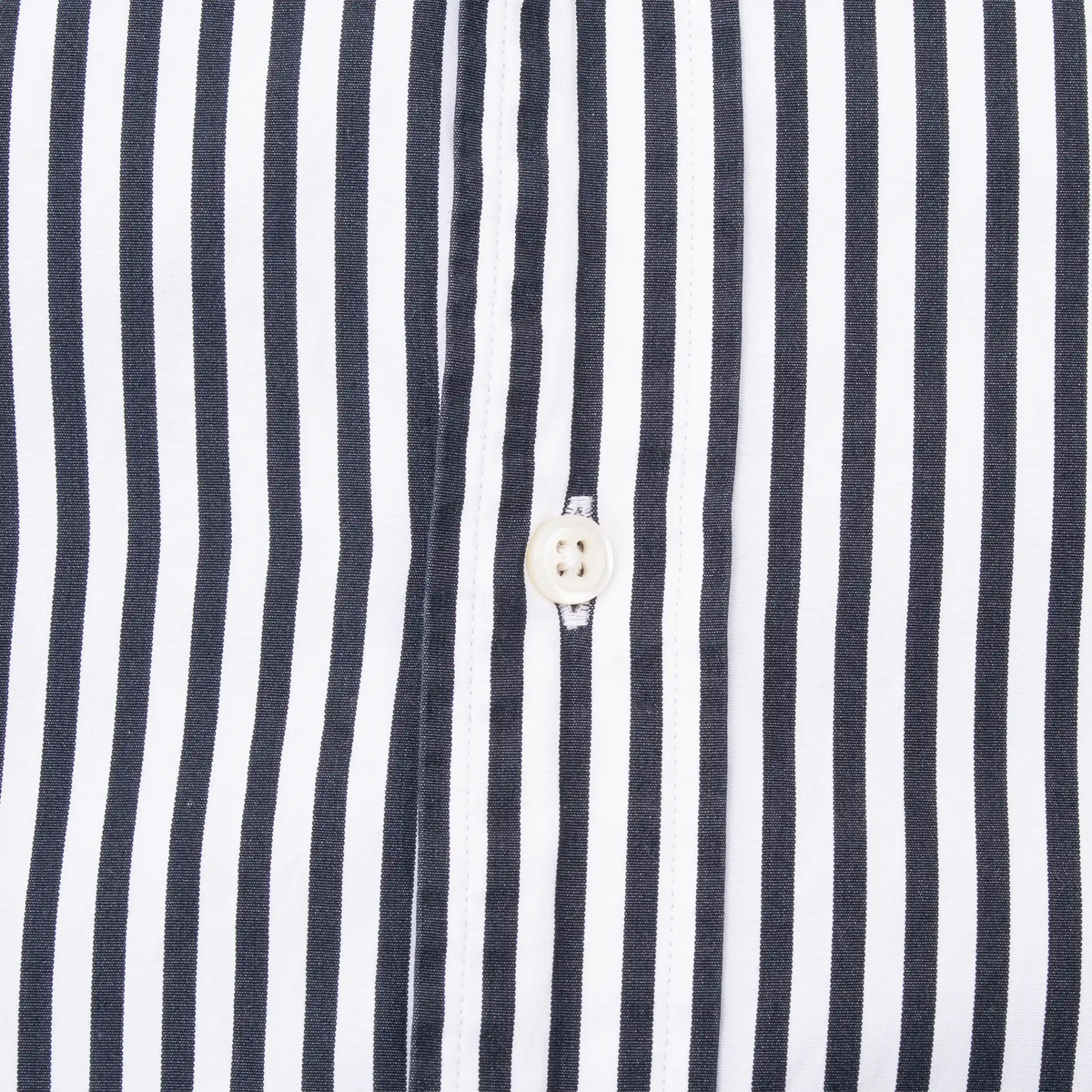White button and stitching detail on black and white striped shirt