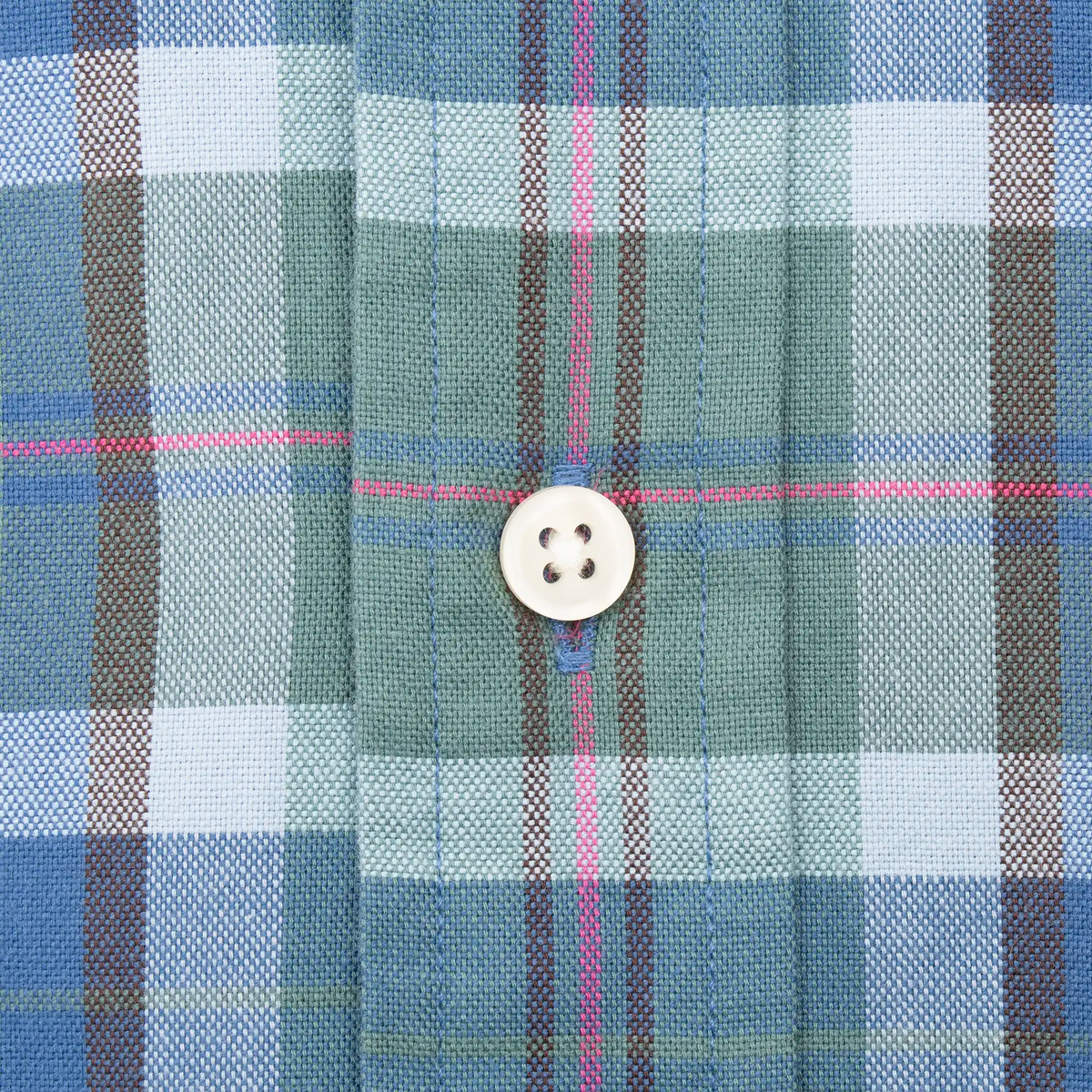 White front button and placket detail on blue and green plaid fabric