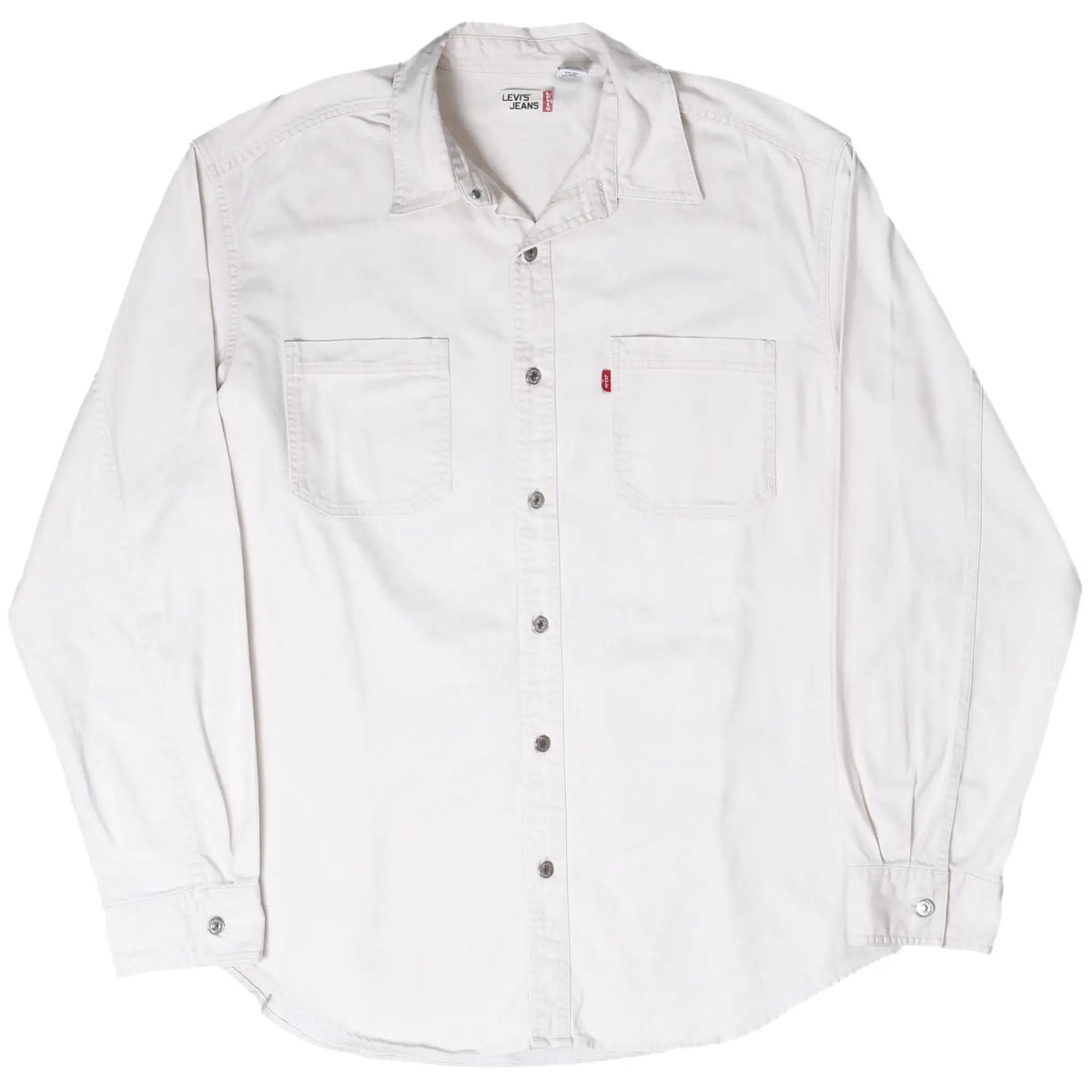 Angled front view of white Levi's denim shirt with two chest pockets and snap-button closure