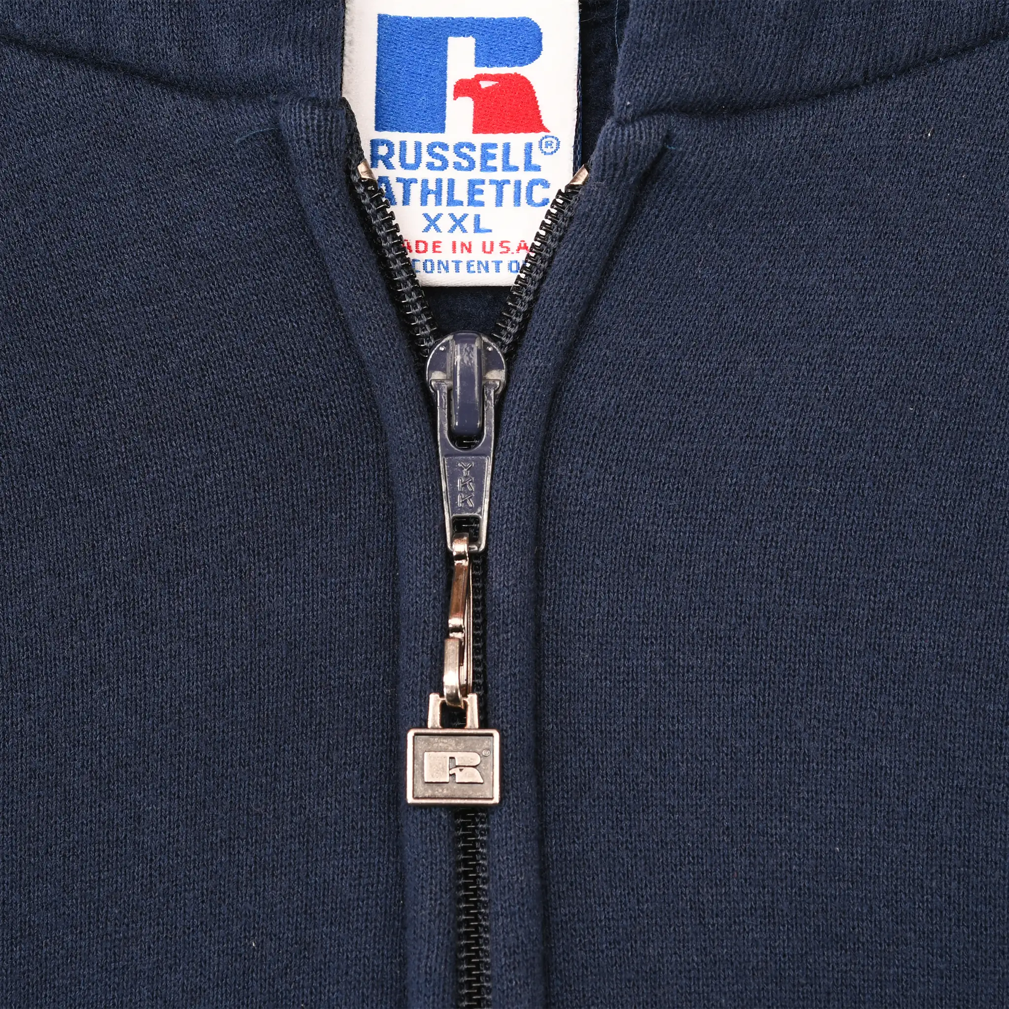 Close-up of Russell Athletic logo zipper pull and neck label on navy hoodie