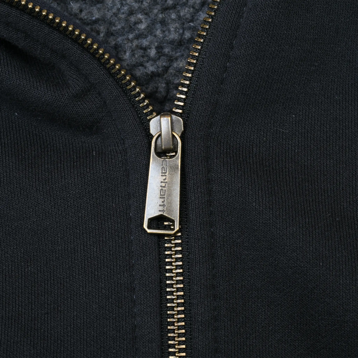 Close-up of Carhartt metal zipper and black sweatshirt fabric