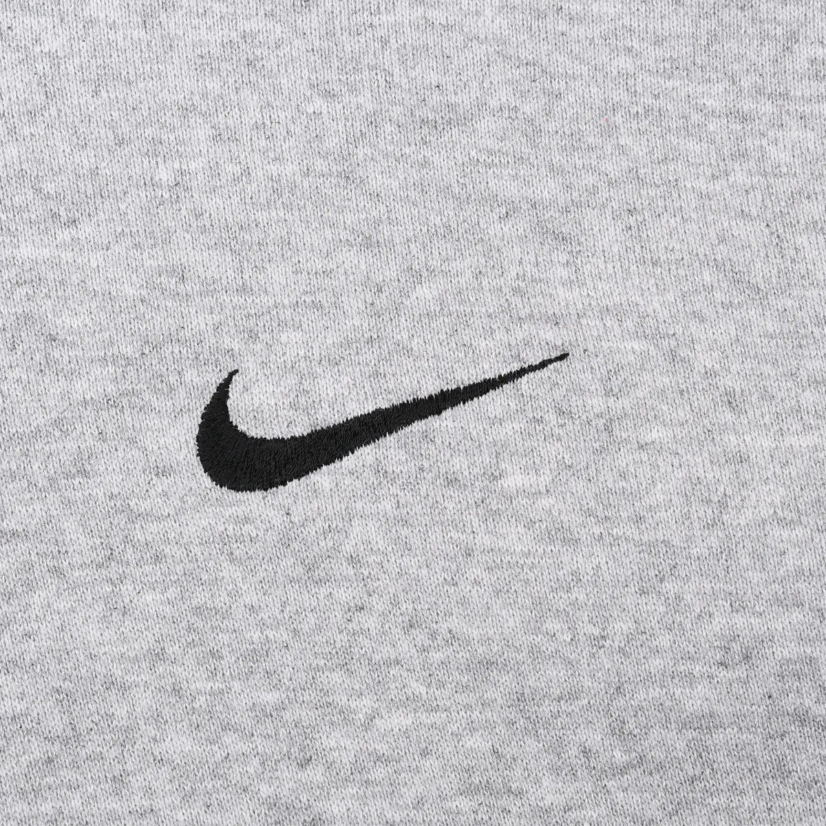 Close-up of black Nike Swoosh embroidery on grey fabric