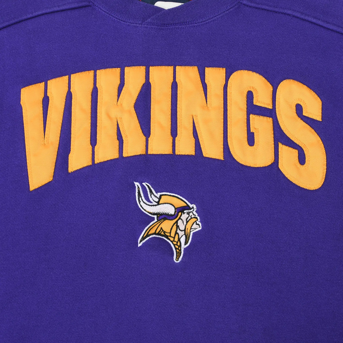 Close-up of gold Vikings lettering and embroidered Minnesota Vikings logo