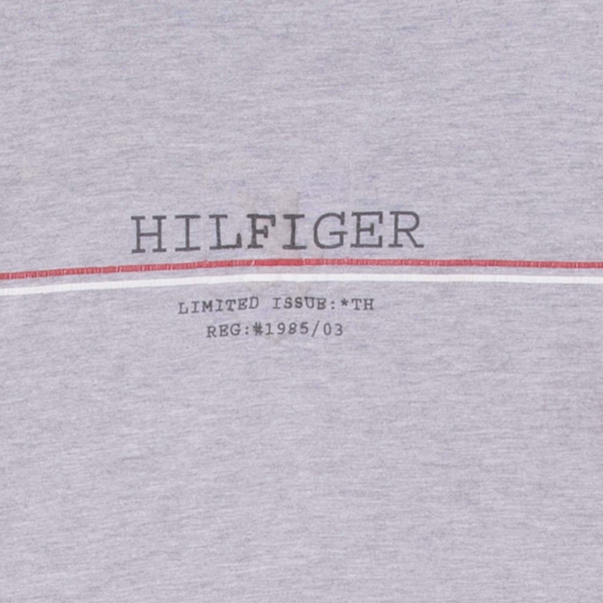 Close-up of Hilfiger chest print and red-white stripe on grey T-shirt