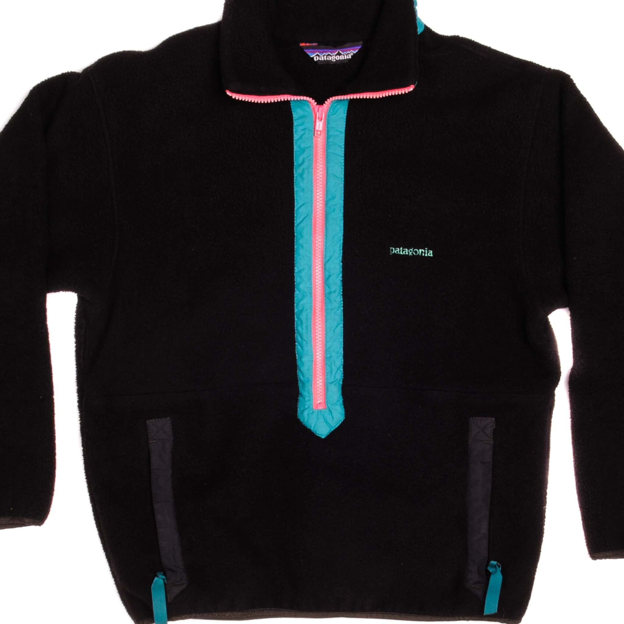 Front of black Patagonia half-zip sweatshirt with teal trim, pink zipper, and chest logo
