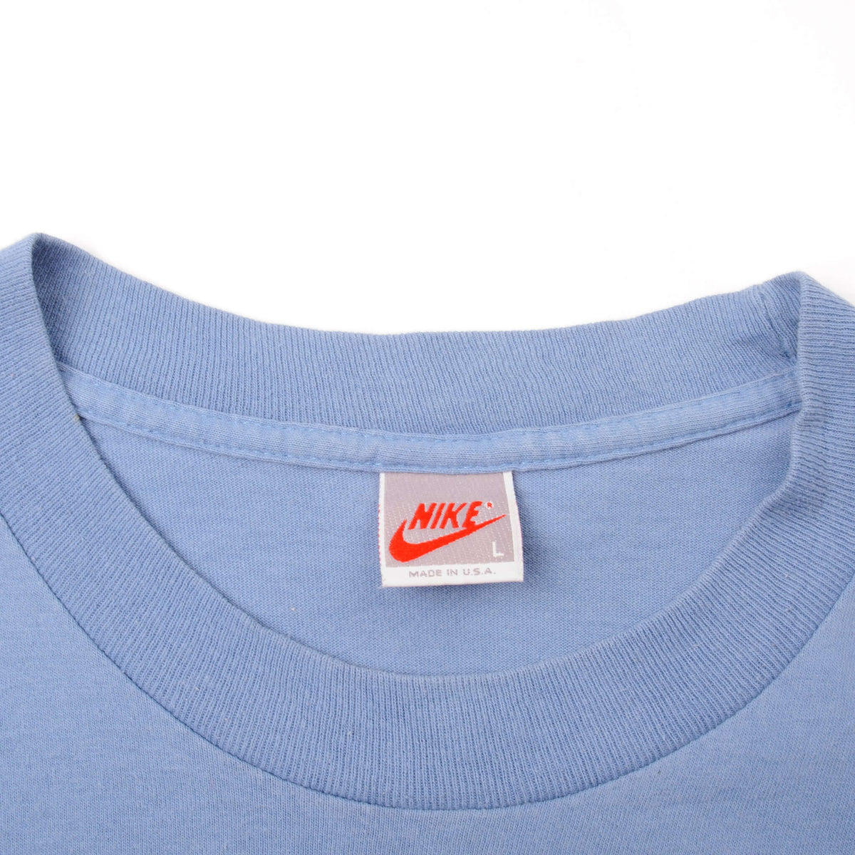 Close-up of Nike size L neck label on blue T-shirt