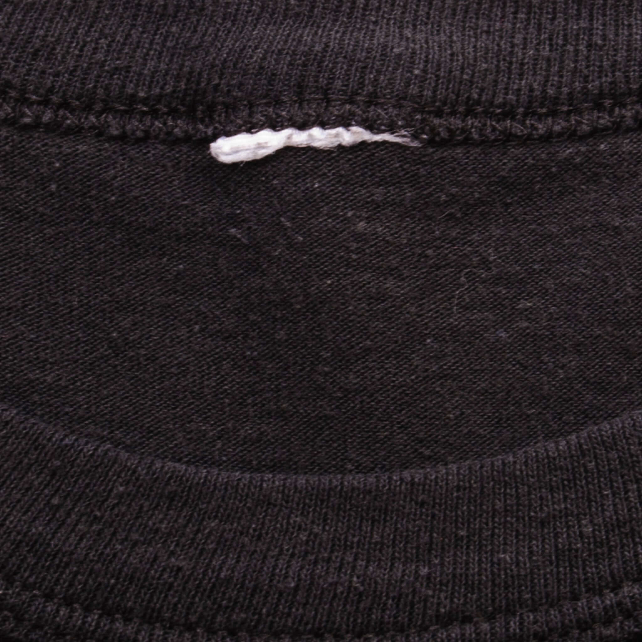Inside collar detail of black Guns N' Roses T-shirt showing stitching and tag remnant