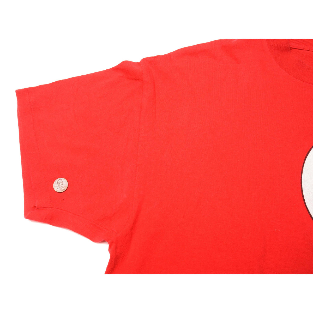 Red T-shirt sleeve shown with a coin for scale