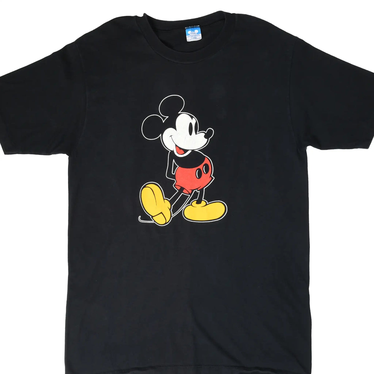 Front of black Disney T-shirt with Mickey Mouse graphic in red shorts and yellow shoes