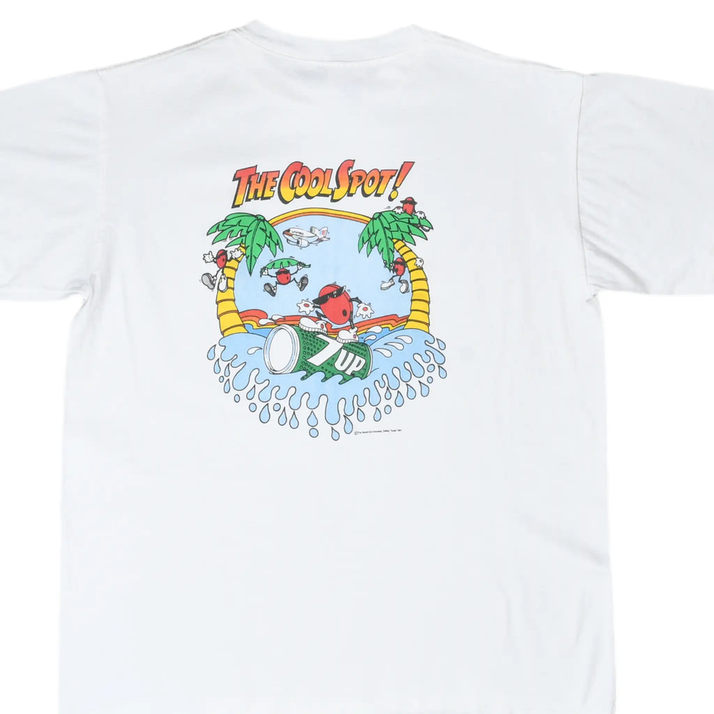 Back of white T-shirt with 7UP Cool Spot surfing graphic, palm trees, splashing waves, and United airplane