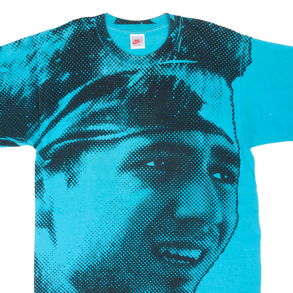 Upper front detail of turquoise Nike Andre Agassi T-shirt with black halftone portrait print