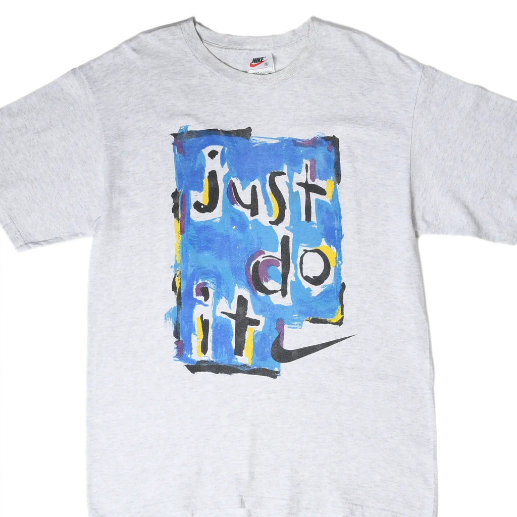 Front close-up of grey Nike T-shirt with blue painted Just Do It graphic and black Swoosh
