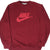 Front of burgundy Nike crewneck sweatshirt with red spellout and Swoosh logo