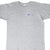 Cropped front view of a heather gray Champion T-shirt with a small blue and red chest logo