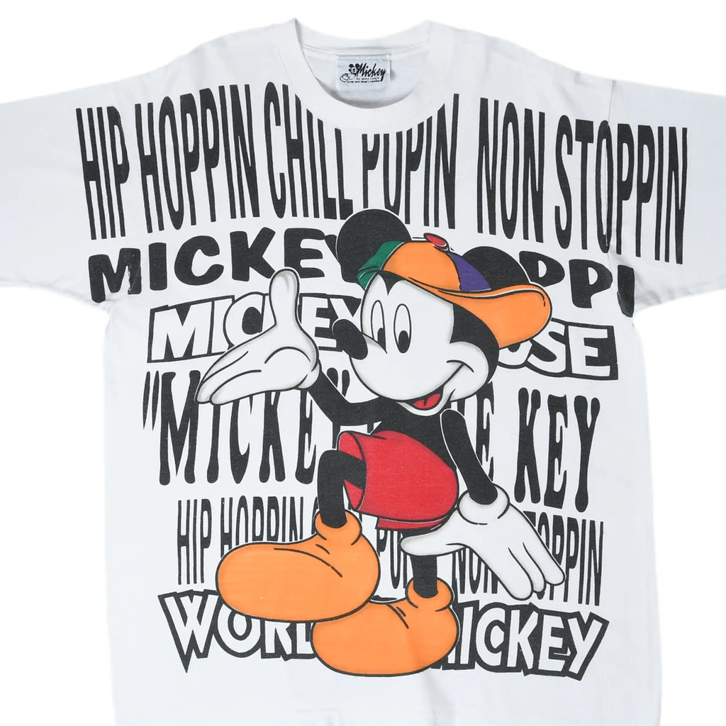 Front of white Disney tee with Mickey Mouse in a colorful cap and all-over hip-hop text print