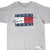 Front close-up of grey Tommy Jeans T-shirt with navy, white and red spellout graphic and hem label
