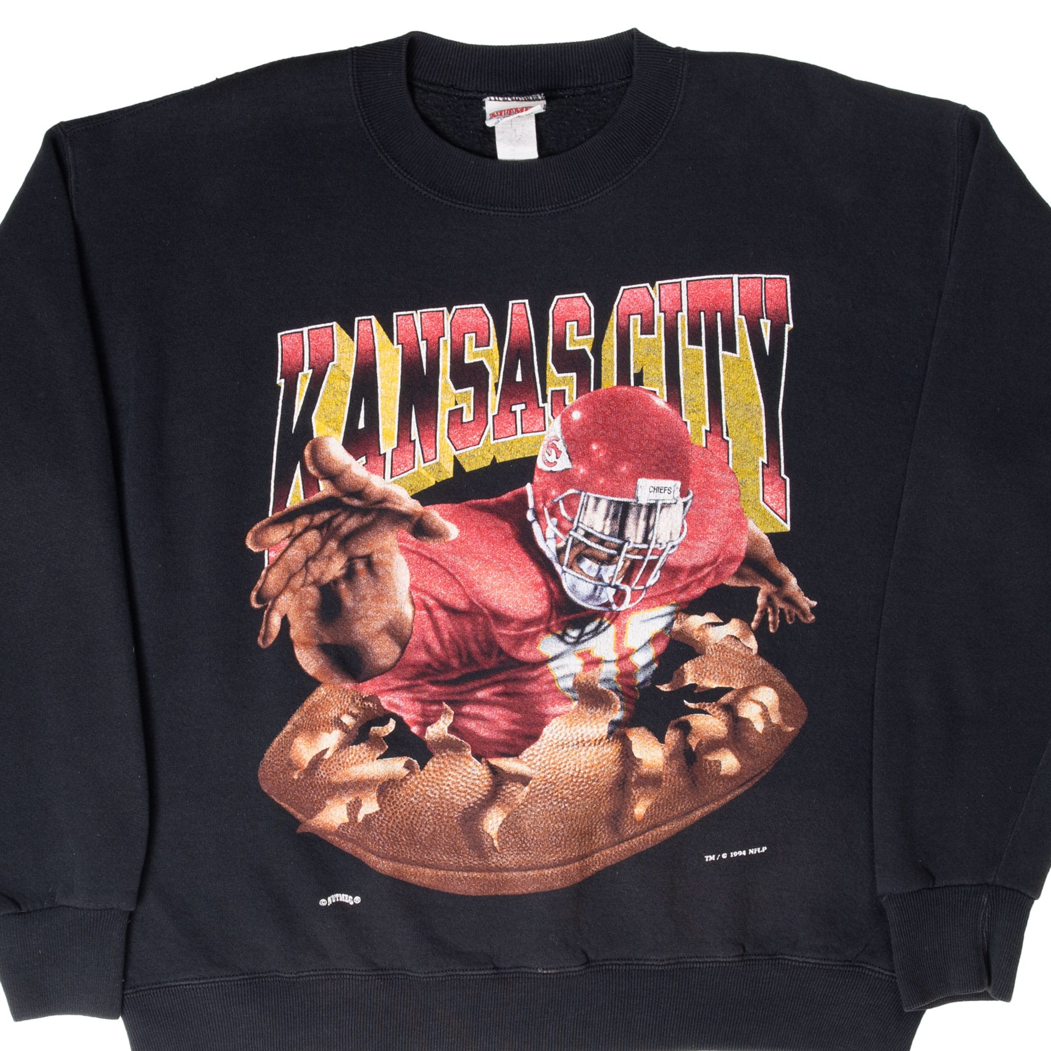 Front of black Kansas City Chiefs sweatshirt with player bursting through a football graphic