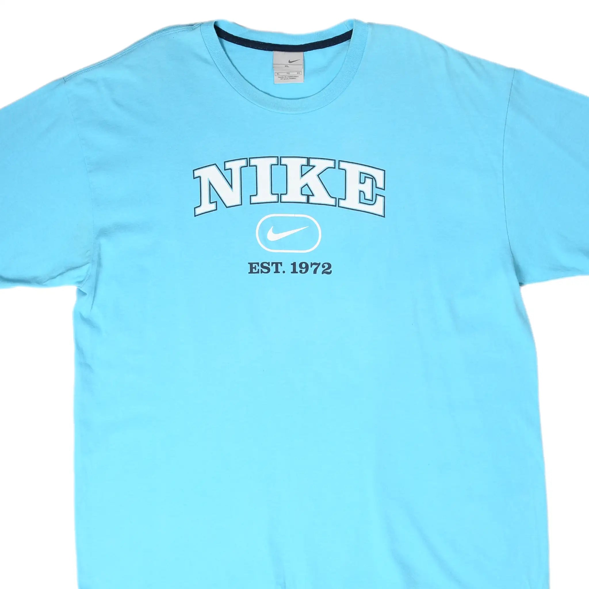 Front close-up of light blue Nike T-shirt with white spellout, Swoosh, and Est. 1972 graphic