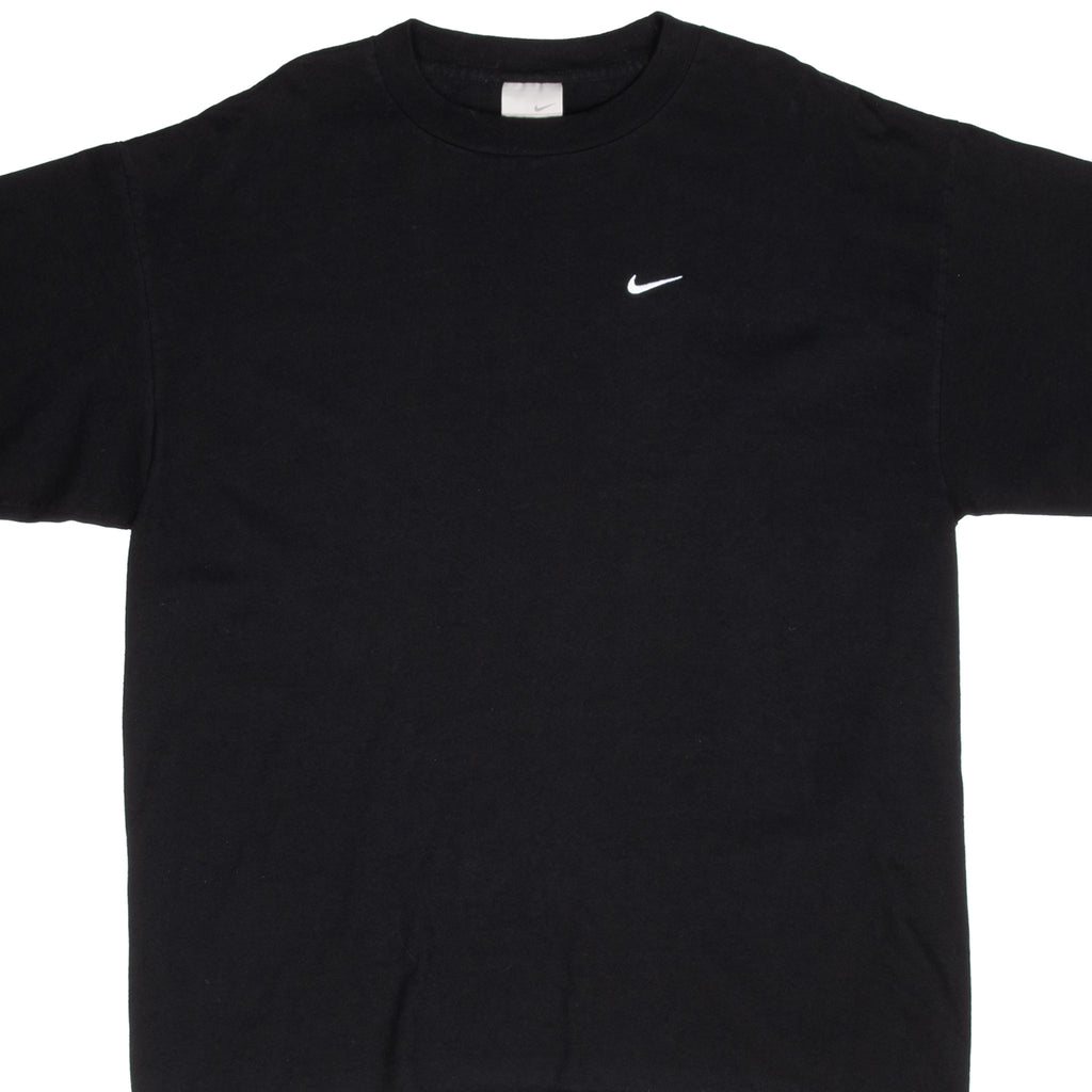 Front upper view of black Nike T-shirt with small white embroidered Swoosh