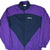 Front of purple and navy Adidas zip-up windbreaker with color-block design and embroidered chest logo